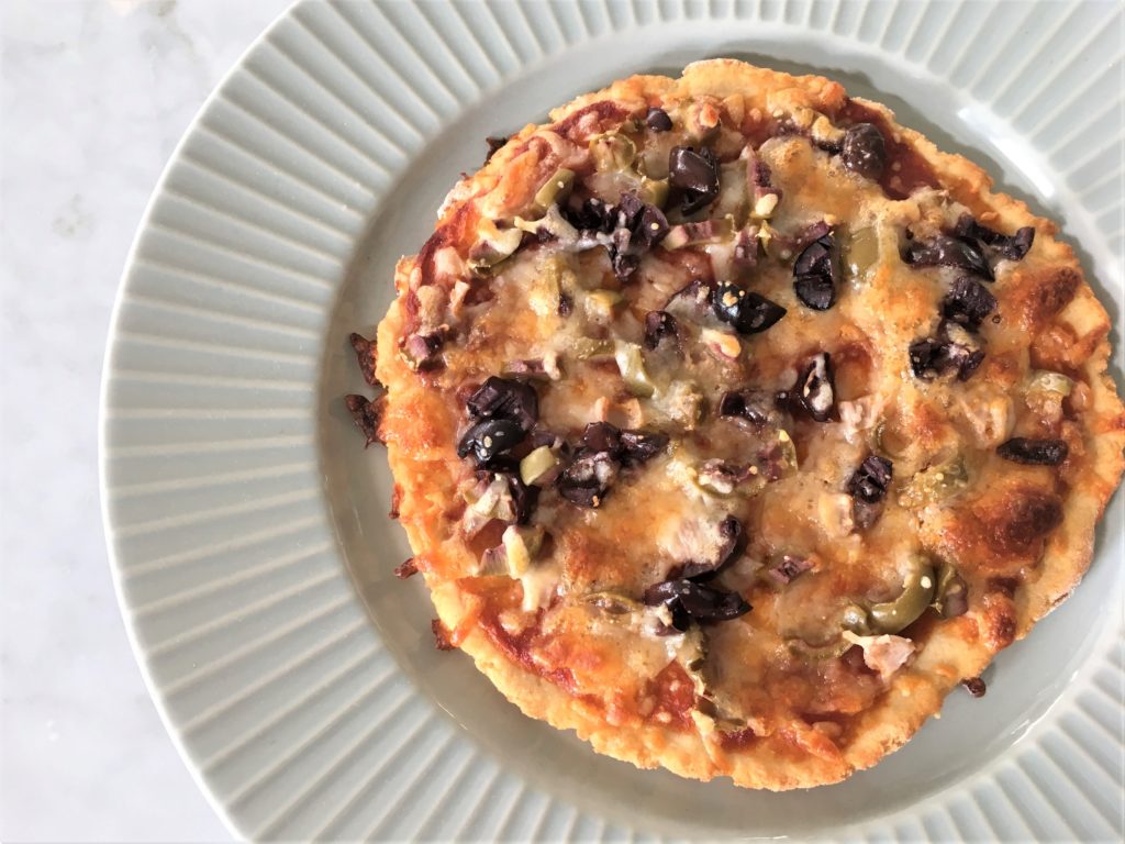 Spring time entertaining is made easy with this healthy weight watchers approved olive pizza! Check out my easy two-ingredient dough that you can make in three minutes, and tastes delicious!